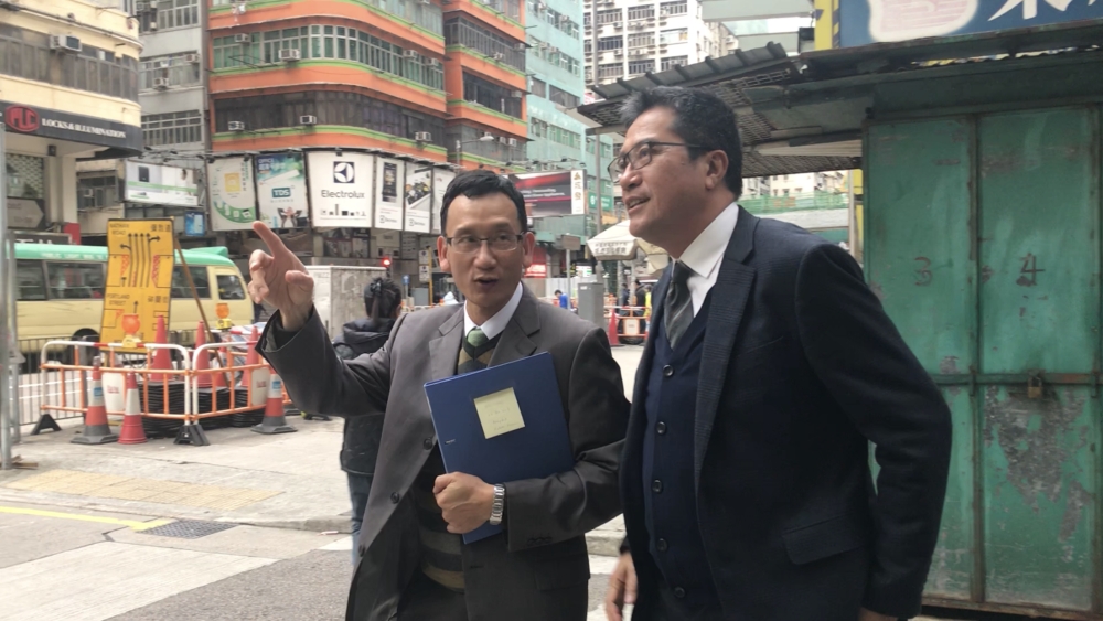 The Secretary for Development (SDEV), Mr WONG Wai-lun, Michael (right), and the Director of Building Rehabilitation of Urban Renewal Authority (URA), Mr HO Chi-wai, Daniel, inspecting loose concrete and rendering on the external walls of Golden Mansion.