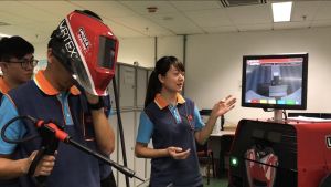 More than 200 trainees are recruited annually under the EMSD’s Technician Training Scheme, including quite a number of female trainees interested in the electrical and mechanical industry.  Pictured is a female trainee showing various training equipment items to the SDEV, Mr Michael WONG.