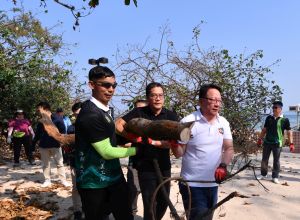 The SDEV, Mr Michael WONG (centre), and the Director of the Chief Executive’s Office, Mr CHAN Kwok-ki, Eric (right), remove fallen trees and rubbish together with a volunteer team from six groups of disciplinary forces at Shek O Beach.