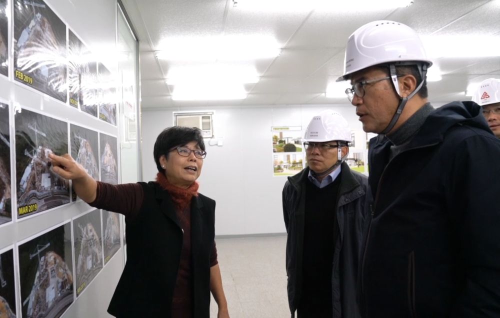 The SDEV, Mr Michael WONG (right), and the PS(W), Mr LAM Sai-hung (centre), are briefed by the Director of Architectural Services, Mrs Sylvia LAM (left), on the construction methods and advantages of MiC.