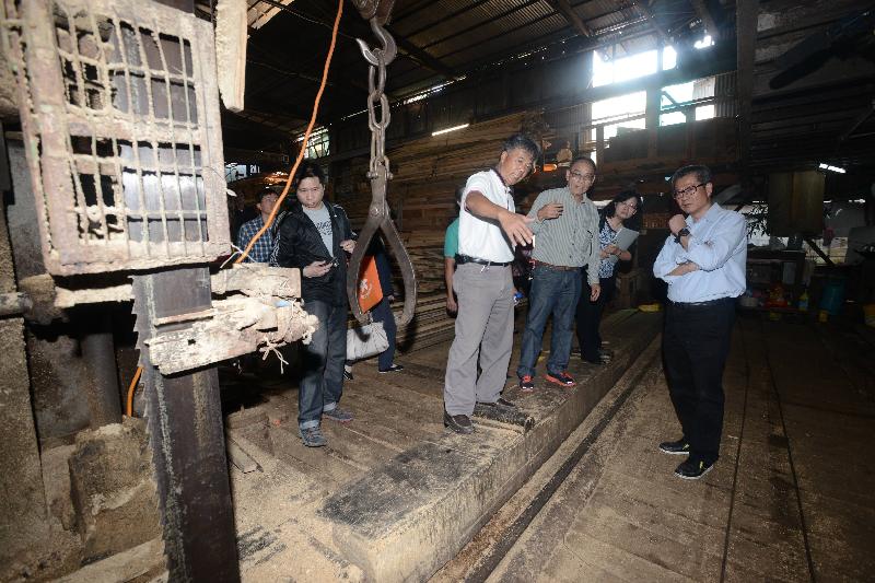 Mr Chan (first right) learns about the daily operation of the sawmill..