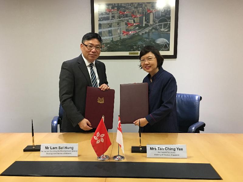 The Permanent Secretary for Development (Works), Mr Lam Sai-hung (left), and the Permanent Secretary of the Ministry of Finance of Singapore, Mrs Tan Ching-yee (right), sign a Memorandum of Understanding in Singapore today (July 30) to enhance collaboration in exchanging expertise and experience in infrastructure project management and delivery.