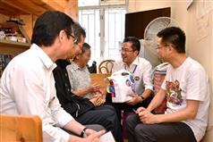 Accompanied by the Chairman of the Sham Shui Po District Council, Mr Ambrose Cheung (second left), the Secretary for Development, Mr Michael Wong (second right); the Director of Buildings, Mr Cheung Tin-cheung (first right); and the Managing Director of the Urban Renewal Authority, Mr Wai Chi-sing (first left), today (July 28) visited a singleton elderly resident living in Un Chau Estate to learn more about her living conditions and needs. Photo shows Mr Wong giving her a gift pack to show his care.