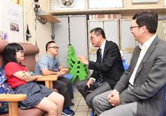 The Secretary for Development, Mr Michael Wong, visited the Hong Kong Down Syndrome Association Tiptop Training Centre during his visit to Sha Tin District today (August 24). Photo shows Mr Wong (second right) and the Under Secretary for Development, Mr Liu Chun-san (first right), chatting with trainees of the centre to learn more about their work and studies.