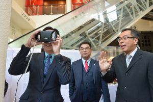 Eric MA (left), Acting Secretary for Development, tries out a virtual reality device.