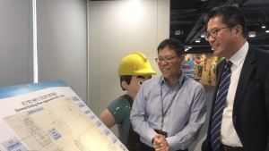 發屋宇署副署長余德祥（左）向黃偉綸局長展示60年代的批准建築圖則。