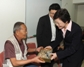 發展局局長林鄭月娥向一名長者致送紀念品。 