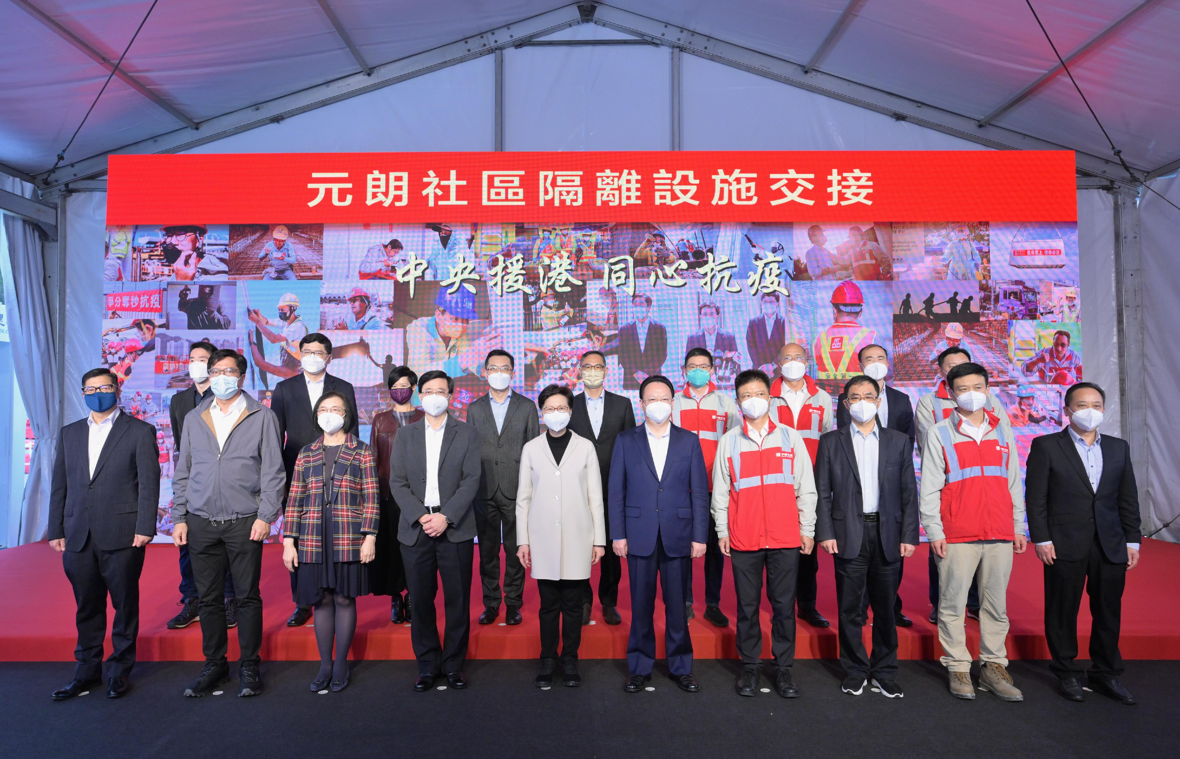 The Chief Executive, Mrs Carrie Lam, this afternoon (March 24) visited the sixth community isolation facility constructed with Mainland support in Yuen Long. Photo shows Mrs Lam (front row, fifth left); the Deputy Director of the Liaison Office of the Central People's Government in the Hong Kong Special Administrative Region Mr Tan Tieniu (front row, fifth right); the Chairman and Non-executive Director of China State Construction International Holdings Limited, Mr Yan Jianguo (front row, fourth right); the Chief Secretary for Administration, Mr John Lee (front row, fourth left); the Secretary for Food and Health, Professor Sophia Chan (front row, third left); the Secretary for Development, Mr Michael Wong (front row, second left); the Secretary for Security, Mr Tang Ping-keung (front row, first left); the Permanent Secretary for Development (Works), Mr Ricky Lau (back row, centre); the Director of Health, Dr Ronald Lam (back row, fourth left); the Director of Architectural Services, Ms Winnie Ho (back row, third left); the Chief Executive of the Hospital Authority, Dr Tony Ko (back row, second left), and other guests at the event.