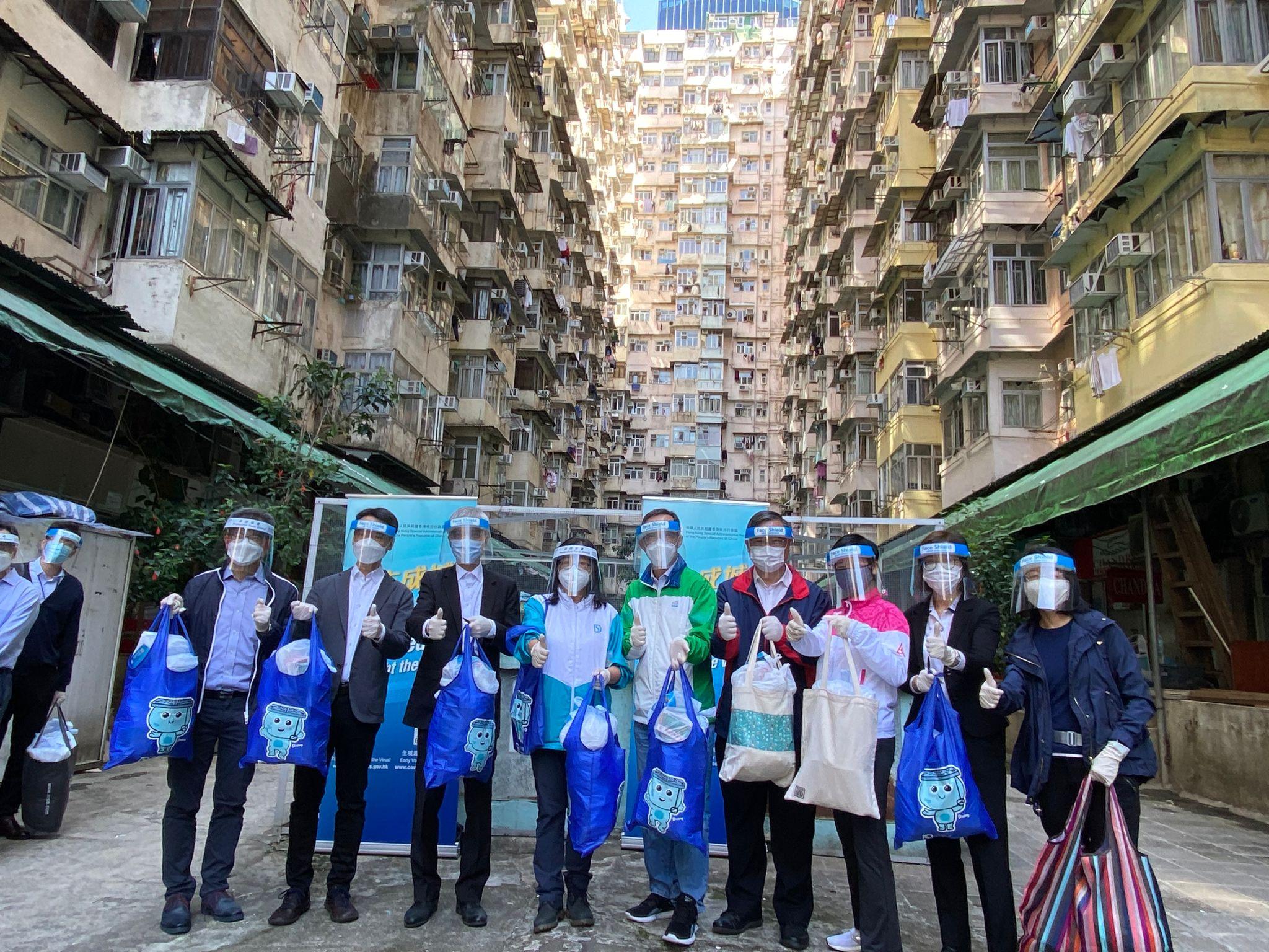 The Secretary for Development, Mr Michael Wong, together with staff members from the Development Bureau and the departments under its purview, today (April 4) distributed anti-epidemic service bags to residents including grassroots families in Quarry Bay. Photo shows (left to right) the Director of Lands, Mr Andrew Lai; the Director of Planning, Mr Ivan Chung; the Director of Water Supplies, Mr Kelvin Lo; the Director of Drainage Services, Ms Alice Pang; the Acting Director of Civil Engineering and Development, Mr Lai Cheuk-ho; the Director of Electrical and Mechanical Services, Mr Eric Pang; the Director of Architectural Services, Ms Winnie Ho; the Director of Buildings, Ms Clarice Yu; and the Land Registrar, Ms Joyce Tam, before distributing the service bags.