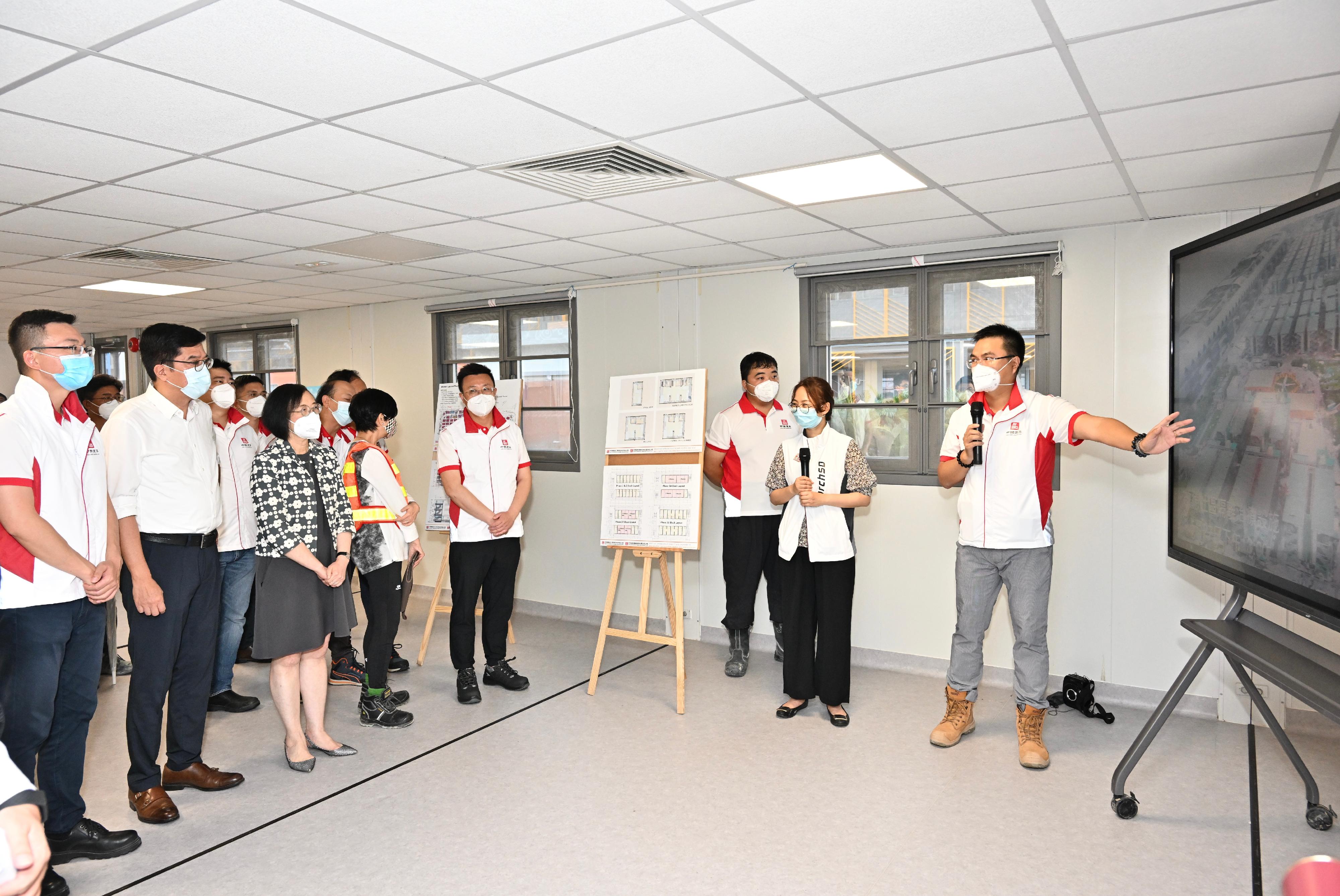 The Secretary for Development, Mr Michael Wong, and the Secretary for Food and Health, Professor Sophia Chan, visited the Kai Tak Community Isolation Facility this afternoon (May 27). Photo shows Mr Wong (second left) and Professor Chan (third left) receiving a briefing from a representative of the contractor on the scale and features of the project.