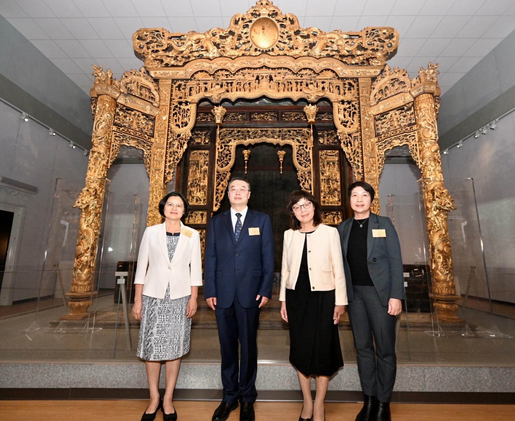 The "Under the Same Roof: Origin and Art of Lingnan Traditional Architecture" exhibition officially opened today (December 12). The Secretary for Development, Ms Bernadette Linn (second right); the Director of Art Exhibitions China, Mr Tan Ping (second left); the President of the Cultural Affairs Bureau of the Government of the Macao Special Administrative Region, Ms Leong Wai-man (first right); and the Deputy Director General of the Guangzhou Municipal Culture, Radio, Television and Tourism Bureau, Ms Ou Caiqun (first left), pictured in front of the star exhibit, Panyu shrine.
