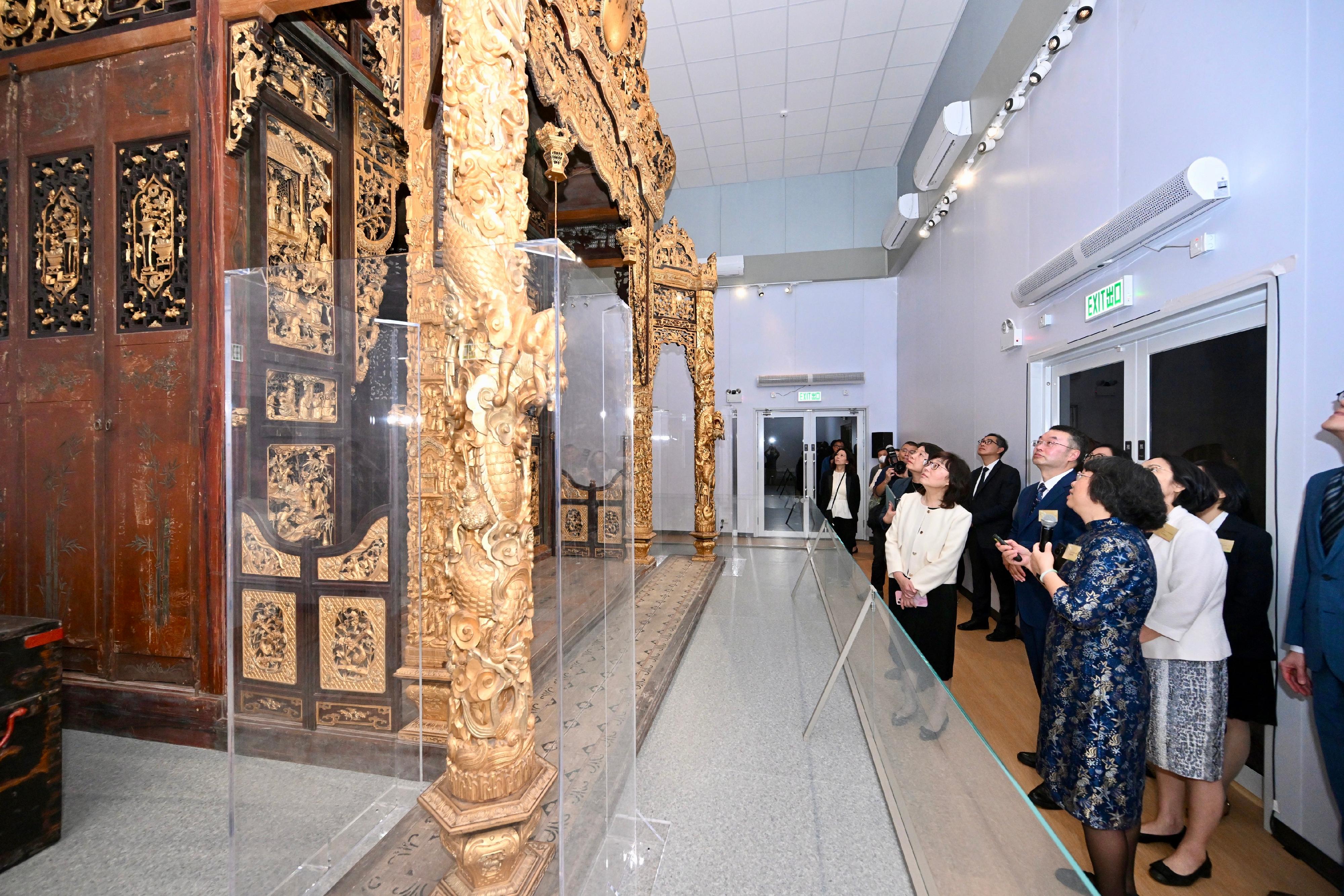 The "Under the Same Roof: Origin and Art of Lingnan Traditional Architecture" exhibition officially opened today (December 12). Photo shows the Secretary for Development, Ms Bernadette Linn (front row, second left), and the Director of Art Exhibitions China, Mr Tan Ping (front row, third left), touring the star exhibit, Panyu shrine.