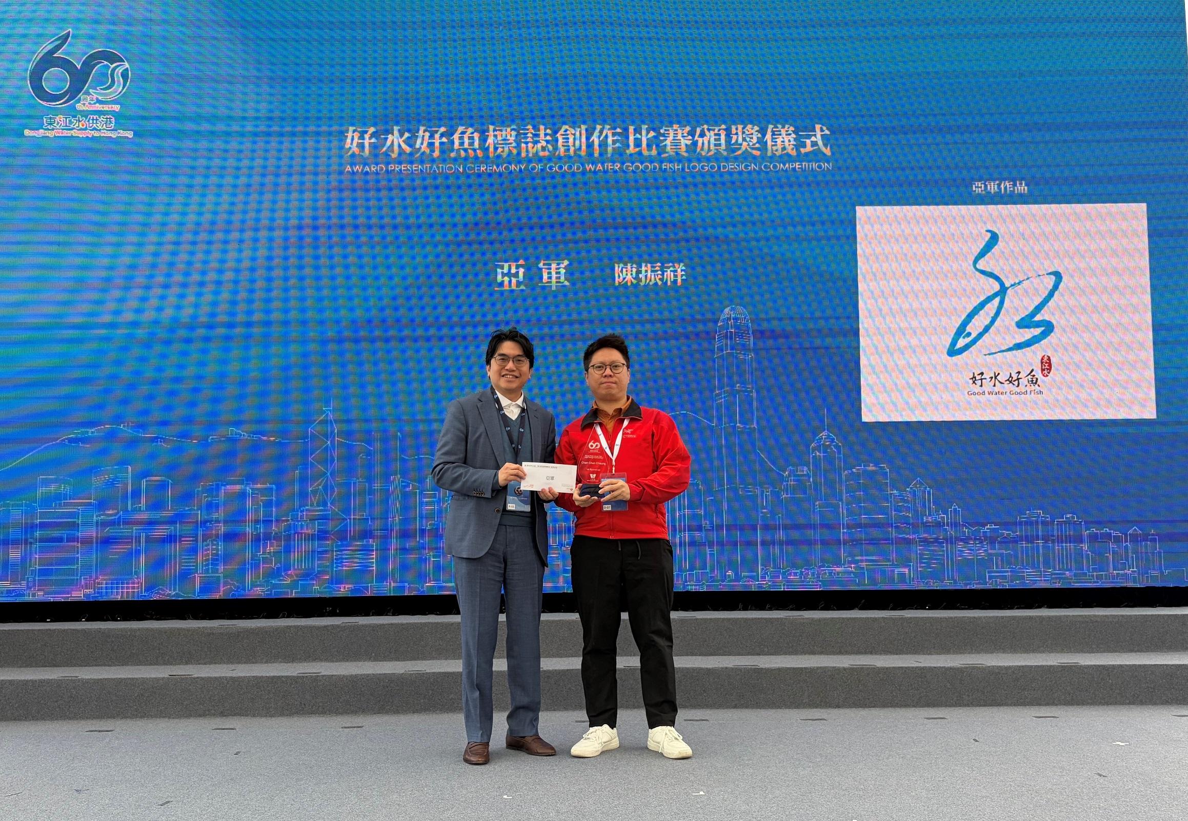 水務署今日（二月一日）在將軍澳海水化淡廠舉行「東江水供港六十周年同樂日」。圖示水務署署長黃恩諾（左）與「好水好魚標誌創作比賽」亞軍得主陳振祥（右）合照。