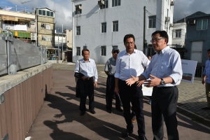 SDEV, Mr Michael WONG (centre), is briefed by DDS, Mr Edwin TONG (right), on the flood prevention measures taken in Tai O and the coastal low-lying areas for typhoons, including the installation of flood barriers at the riverwall in Tai O.