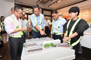 SDEV, Mr Michael WONG (second left), views a model of the CPS Compound and is briefed by the Executive Director of Charities and Community of the HKJC, Mr CHEUNG Leong (first left), on the revitalisation project and its progress.  Beside them are the Chairman of the Central and Western District Council, Mr YIP Wing-shing (second right), and the District Officer (Central and Western), Mrs WONG HO Wing-sze, Susanne (first right).