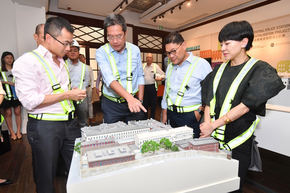 SDEV, Mr Michael WONG (second left), views a model of the CPS Compound and is briefed by the Executive Director of Charities and Community of the HKJC, Mr CHEUNG Leong (first left), on the revitalisation project and its progress.  Beside them are the Chairman of the Central and Western District Council, Mr YIP Wing-shing (second right), and the District Officer (Central and Western), Mrs WONG HO Wing-sze, Susanne (first right).