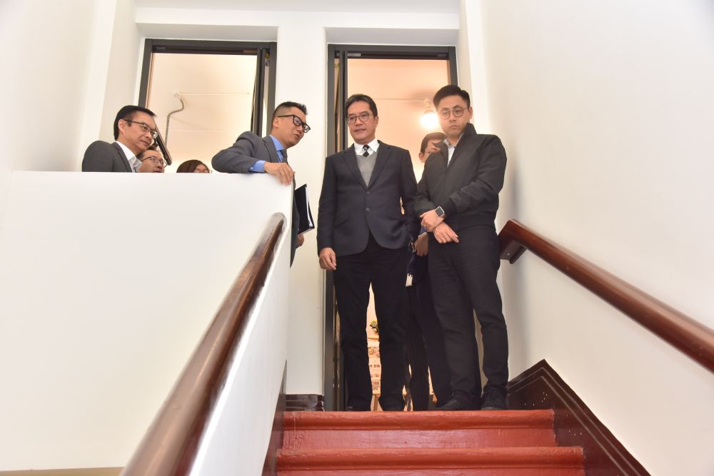 Mr Lawrence MAK, General Manager (Planning and Design) of the Urban Renewal Authority (second left) briefs Mr Michael WONG, Secretary for Development (SDEV) (second right), Mr Chris IP, Chairman of the Yau Tsim Mong District Council (YTMDC) (first right) and Mr WAI Chi-sing, Managing Director of URA (first left) about the main architectural features of the tenement building, including the original staircases.