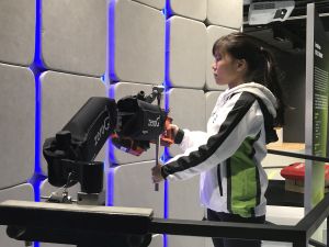 A staff member of the Centre demonstrates how to use Zero G arms to comfortably operate heavy tools and hence improve occupational safety.