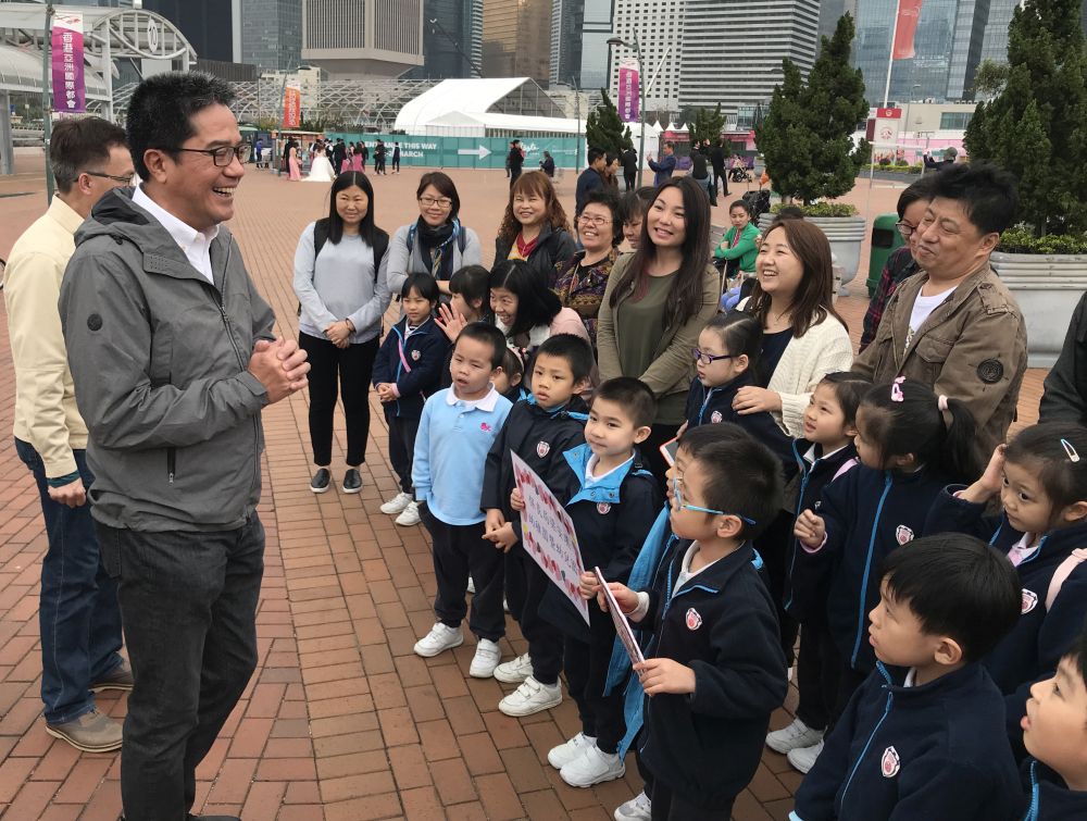 Mr Michael WONG, SDEV; Mr LIU Chun-san, Under Secretary for Development (USDEV); Mr Allen FUNG, Political Assistant (PA) to SDEV, together with kindergarten children and their parents, posing for a group photo in front of the Observation Wheel at the Central Harbourfront.