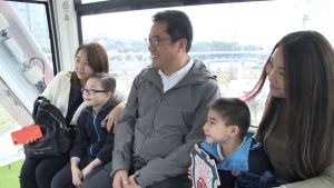 Mr Michael WONG, SDEV; Mr LIU Chun-san, USDEV; Mr Allen FUNG, PA to SDEV and kindergarten children and their parents taking a group photo inside a gondola of the big wheel.