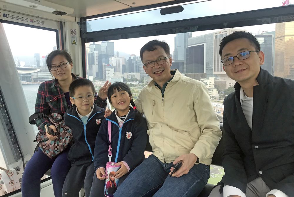 Mr Michael WONG, SDEV; Mr LIU Chun-san, USDEV; Mr Allen FUNG, PA to SDEV and kindergarten children and their parents taking a group photo inside a gondola of the big wheel.