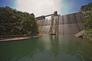 Pictured is the Tai Tam Tuk Reservoir Dam and people can travel by vehicle through the carriageway over the dam.