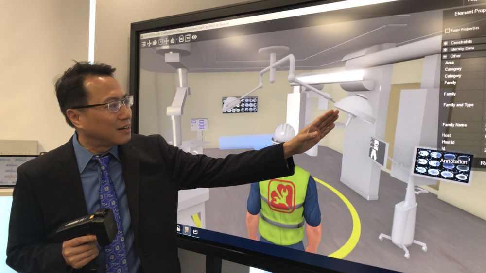Senior Engineer of the EMSD, Mr CHAN Hor-yin, Steve (right), illustrates how the EMSD applies the Building Information Modelling–Asset Management System to conduct smart maintenance and repair work.