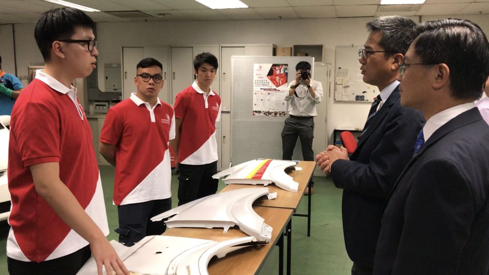 The SDEV, Mr Michael WONG (second right), talks with the trainees who are preparing to enter the Car Painting Competition.