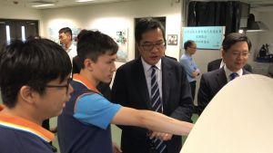 A trainee shows the SDEV, Mr Michael WONG (second right), how to detect vehicle malfunctions with Bluetooth transmitters and computer application programmes.