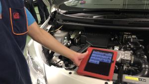 A trainee shows the SDEV, Mr Michael WONG (second right), how to detect vehicle malfunctions with Bluetooth transmitters and computer application programmes.