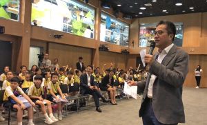 SDEV Mr Michael WONG hosting a quiz. The questions include the land area of Hong Kong, the number of new towns and new development areas, etc. The response is overwhelming as students scramble to answer the questions.