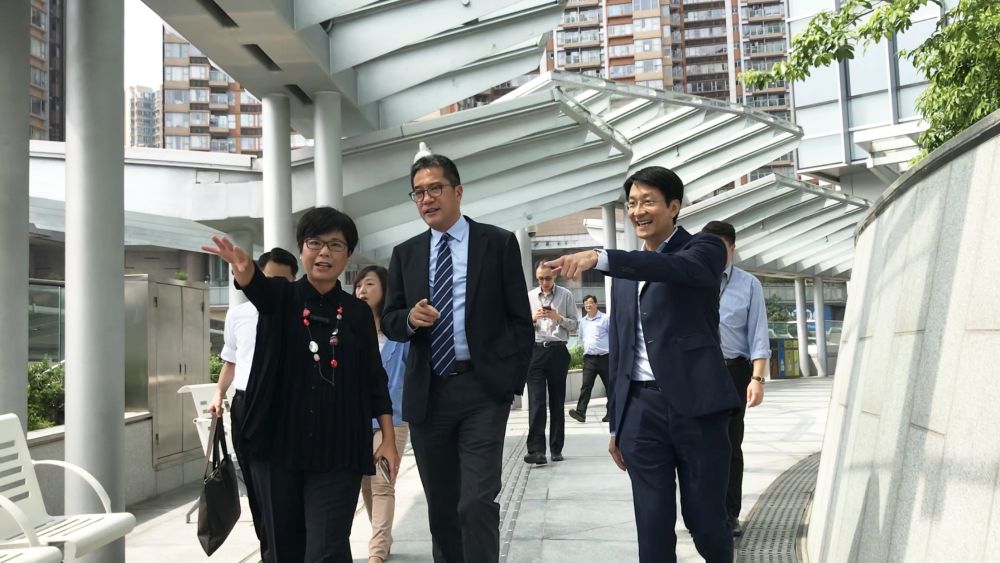 Project Director of the Architectural Services Department (ArchSD), Mr WONG Tak-choi, Frank (right), briefs the SDEV, Mr Michael WONG (centre), on the layout of the walkways outside the TI Tower. The planning and design of the TI Tower aim to provide an array of walkways and footbridges that run through different locations to enhance connectivity.