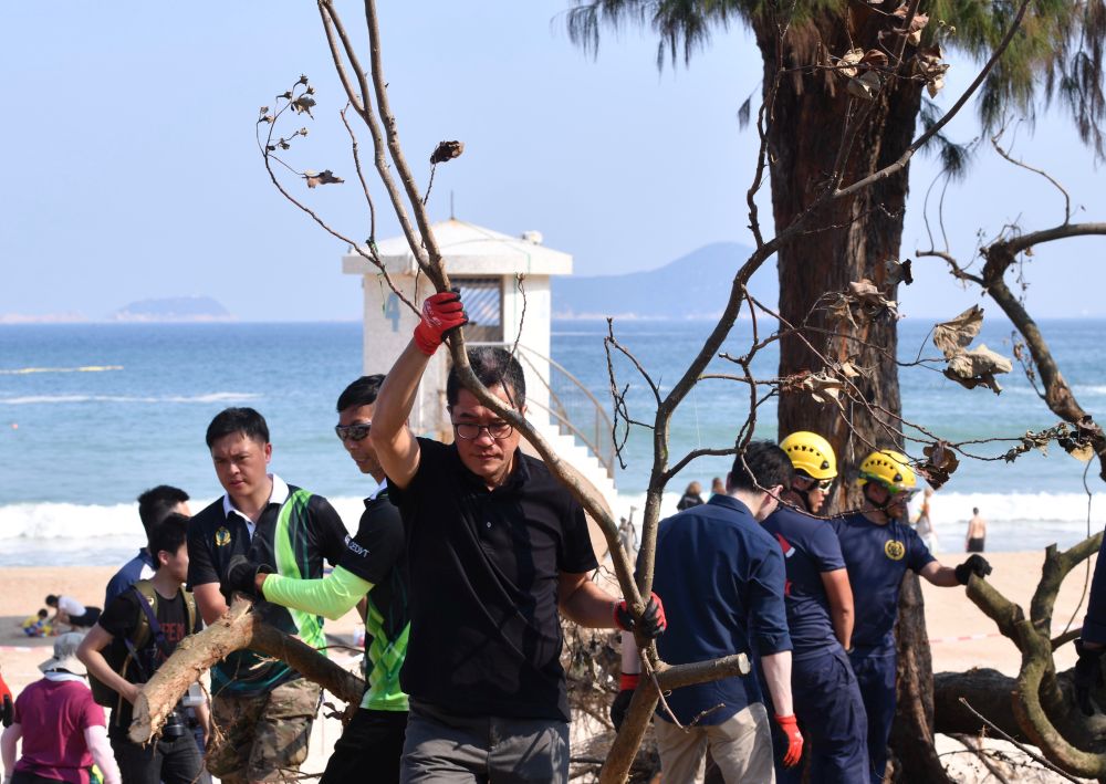 The SDEV, Mr Michael WONG, helps clear the fallen trees at Shek O Beach.