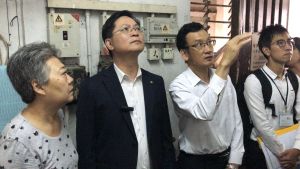 Accompanied by the treasurer of the OC of Kin Fook Mansion, Mrs LAU (first left), the DEMS, Mr Alfred SIT (second left), and the Director of Building Rehabilitation of the URA, Mr Daniel HO (third left), go to the top floor of the building to inspect the facilities in the machine room of the lifts.