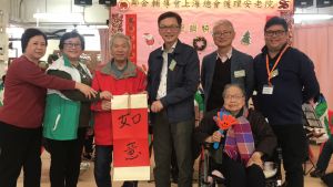 The Under Secretary for Development (USDEV), Mr LIU Chun-san (third right), shows his support for the two volunteer groups, while a senior gives him a piece of Chinese calligraphy (Fai Chun) to express appreciation.