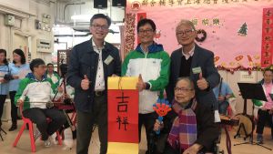 The Under Secretary for Development (USDEV), Mr LIU Chun-san (third right), shows his support for the two volunteer groups, while a senior gives him a piece of Chinese calligraphy (Fai Chun) to express appreciation.