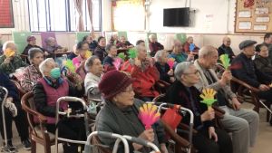 While the volunteers are giving impromptu performances to the elderly, such as playing Chinese music and singing, the elderly are getting a big laugh. The atmosphere is filled with warmth and excitement.