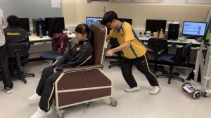 Considerable weight will be added to a Geri chair when an elderly person sits on it, making it difficult for a carer to move it. The students have invented an electric mini pallet truck that can help reduce their burden in moving around the Geri chairs.