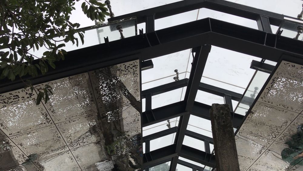 The reflective sun-shading sheets of the new rain shelter are cast with laser printing to capture the effect of shadow caused by leaves on to the ground. 