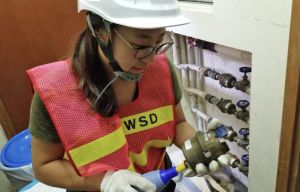 The main duties of an Artisan (Civil) of the WSD include replacing aged meters, handling customer enquiries on water quality and supply, and conducting accuracy tests on aged meters (as pictured).