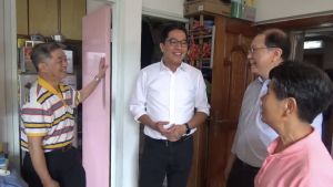 Mr LAM and his wife (first left and first right) tell Mr Michael WONG, the SDEV (second left) and Mr Jacky IP (second right) of the HKHS about the subsidised repair works carried out in their home. 