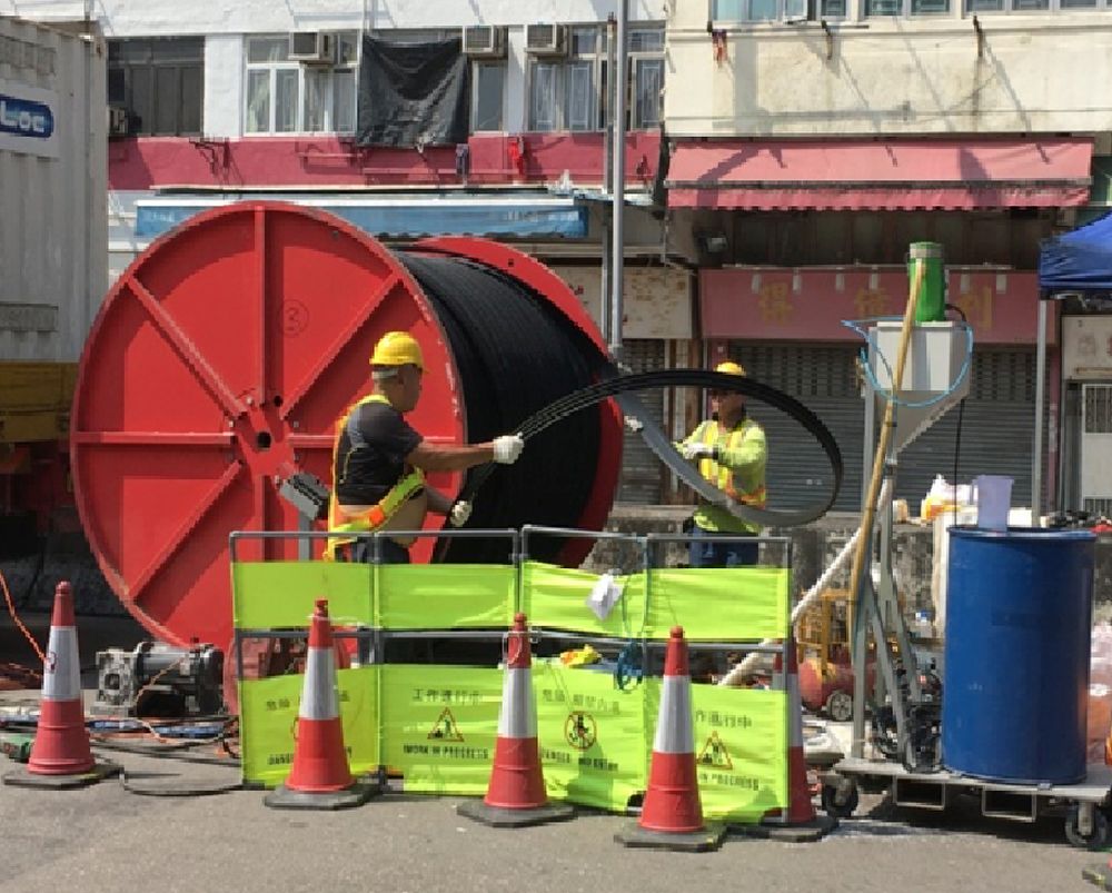 Workers are rehabilitating pipes using the spirally-wound lining technology.