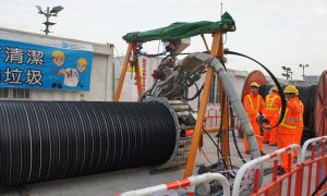 Workers are rehabilitating pipes using the spirally-wound lining technology.