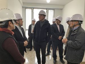 The SDEV, Mr Michael WONG (third left) pays a visit to a precast unit that has just been assembled. He sees that some essential fittings, partitions and fixtures (such as ceiling lights, floor tiles, windows and window grilles) are already in place. 
