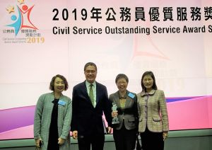 The Secretary for Development, Mr WONG Wai-lun, Michael (second left), congratulates the colleagues who are honoured with the Departmental Service Enhancement Award (Small Department Category) of the Civil Service Outstanding Service Award Scheme 2019. He takes a group photo with the Land Registrar, Ms CHEUNG Mei-chu, Doris (first right), the Registry Manager of the Land Registry (LR), Mrs FONG NG Suk Yee, Amy (second right) and the Business Manager of the LR, Ms POON Suet-chung, Venelie (first left) after the prize presentation ceremony.