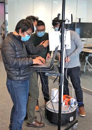 The project team of the technology company is installing and testing the mobile fever screening robot.