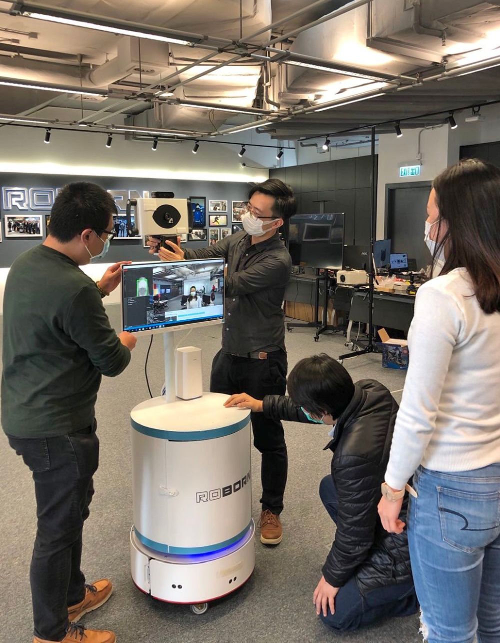 The project team of the technology company is installing and testing the mobile fever screening robot.