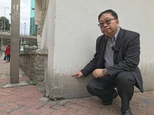 Mr Edmond YU, Chief Land Surveyor of the LandsD, briefs us on the boundary stones used to demarcate land lots before the 1970’s, taking the one at the corner of a building in North Point for an example.