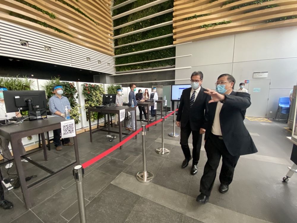 Accompanied by the Director of Electrical and Mechanical Services (DEMS), Mr PANG Yiu-hung (right), the Secretary for Development (SDEV), Mr WONG Wai-lun, Michael (left), visits the Electrical and Mechanical Services Department (EMSD) Headquarters. The SDEV is briefed by the DEMS on the details of COVID-19 testing services for high-risk target groups.