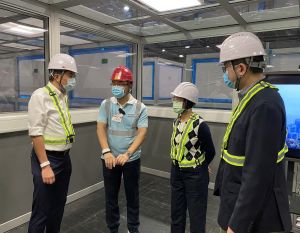 The SDEV, Mr Michael WONG (first left), the Secretary for Food and Health, Professor Sophia CHAN (second right), and the Chief Executive of the HA, Dr Tony KO (first right), are briefed by the representative of the contractor, China State Construction Engineering (Hong Kong) Limited (second left), on the negative pressure enclosed cubicles in the AWE.